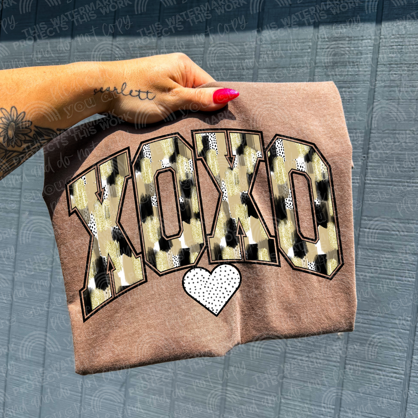 Brown shirt with the word xoxo in a gold and camo print with a black and white polka dot heart underneath it. perfect for a valentines t-shirt. 