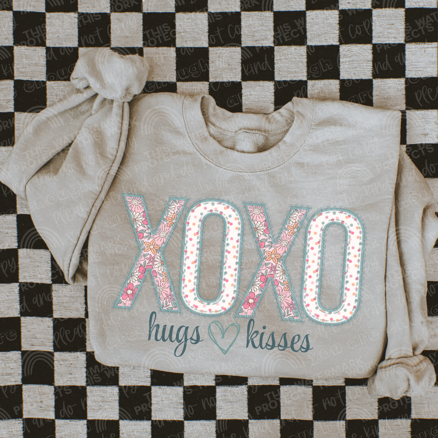 Taupe crewneck with words xoxo and hugs and kisses underneath. The xoxo has a floral and multicolored polka dot print inside of the letters. Perfect for a valentines t-shirt. 